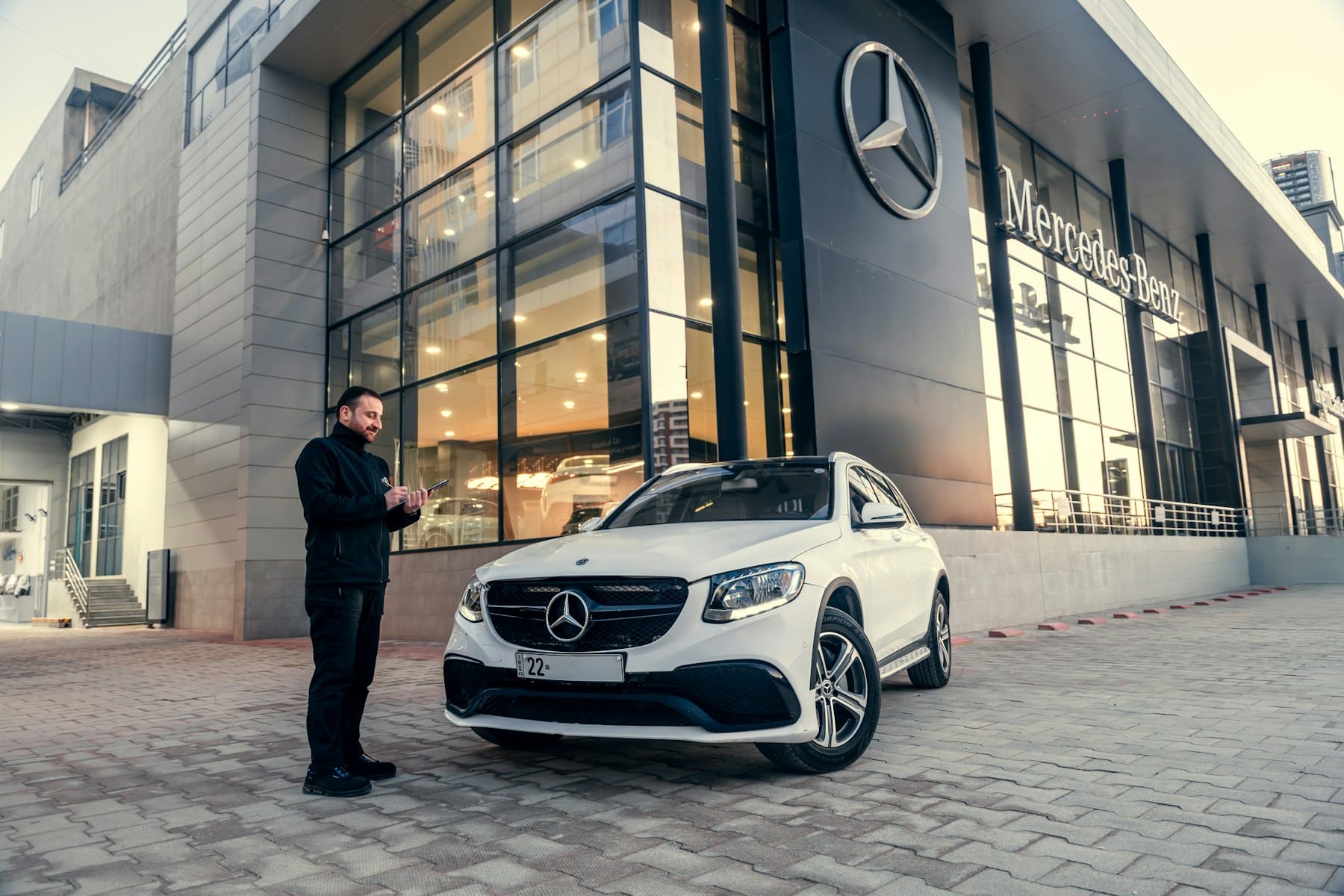 Salesperson standing beside a vehicle at a dealership